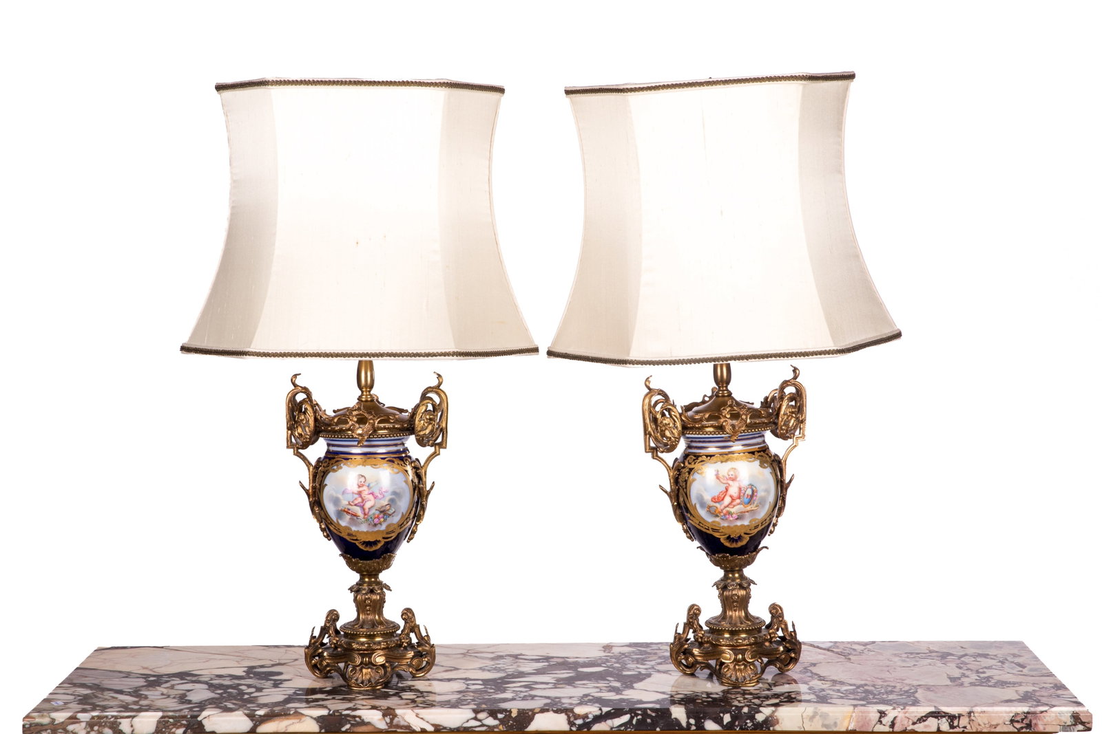 PAIR OF FRENCH PORCELAIN VASES AS TABLE LAMPS: Cobalt vases with hand painted bouquets on one side and putti on the reverse, bronze mounts, converted to table lamps, Sevres style. Overall H 31in H 14 1/2in