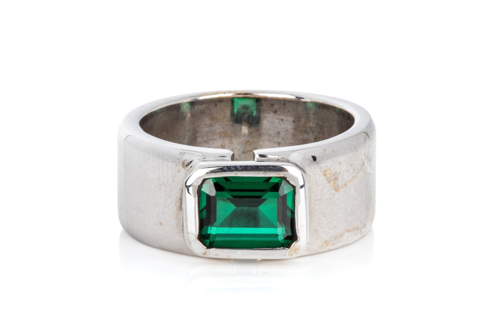 14K WHITE GOLD & GREEN SPINEL RING 17.4g: 14K white gold ring measuring 10mm wide consistently, by 4mm tall. Featuring 1 bezel set emerald cut green spinel. Size 9 17.4 grams total weight