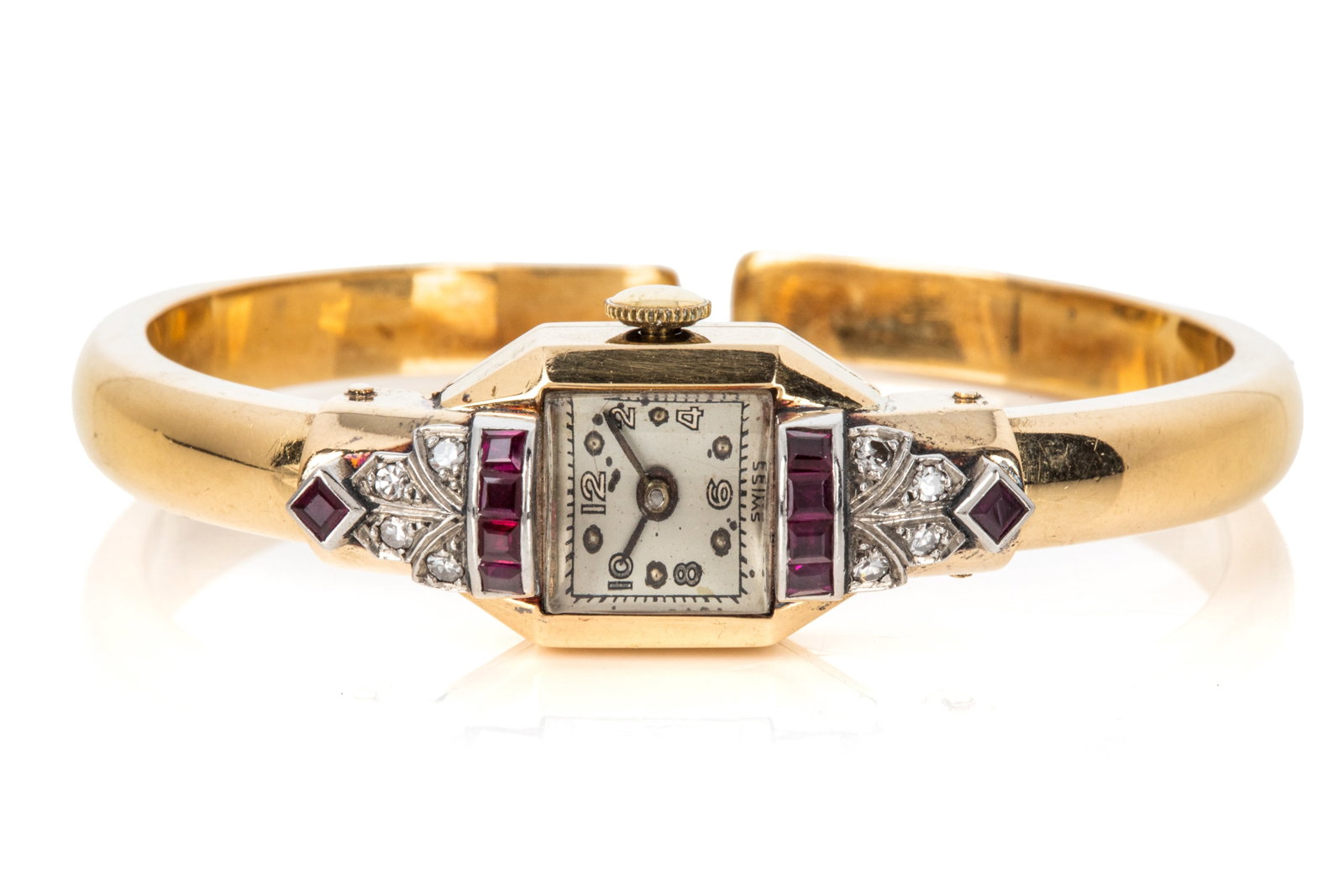 18K DIAMOND & RUBY COCKTAIL CUFF WATCH 26.8g: 18K yellow gold and sterling silver cuff cocktail watch, Swiss made mechanical movement, plastic dome crystal, case measuring 31.7mm long by 13.5mm wide. Spring-loaded cuff arms measuring 6mm wide. Ac