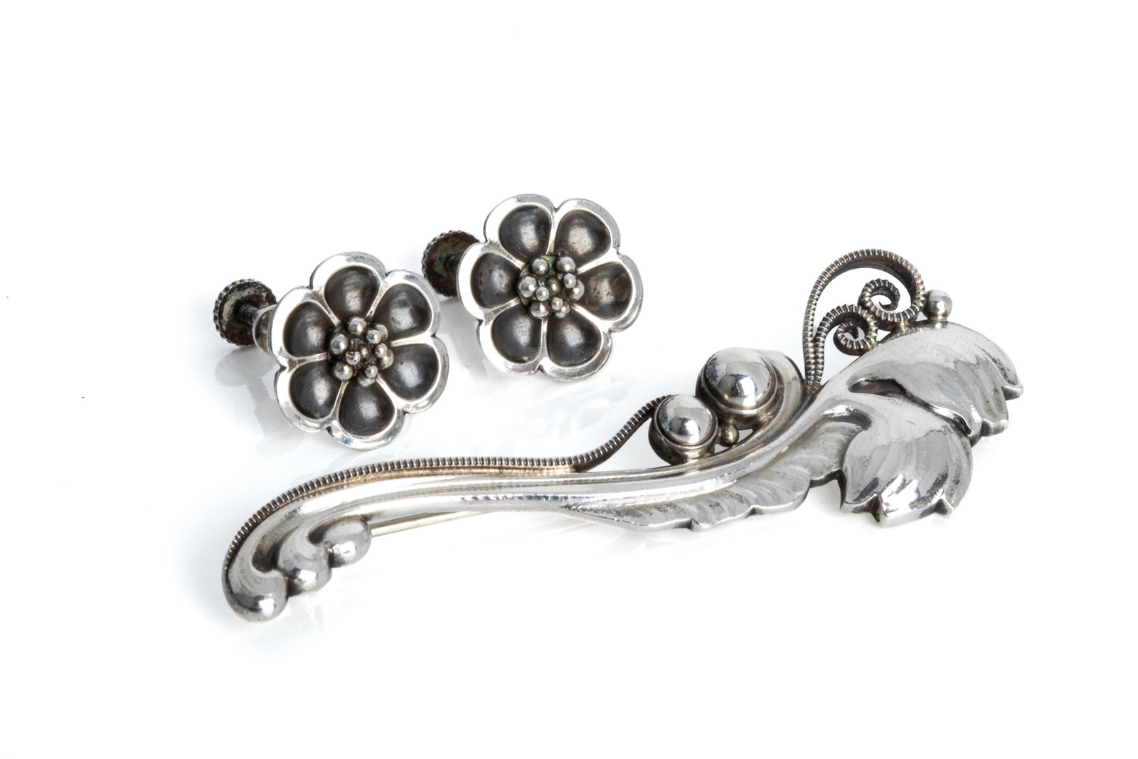 GEORG JENSEN FLORAL JEWELLERY, 181B & 67: Vintage Georg Jensen sterling silver floral brooch, model 181B with "silver pearls", post-1945 hallmarks, with round hinge and roll lock. Measuring 72.8mm by 26.3mm. 15.7 grams Vintage Georg Jensen st
