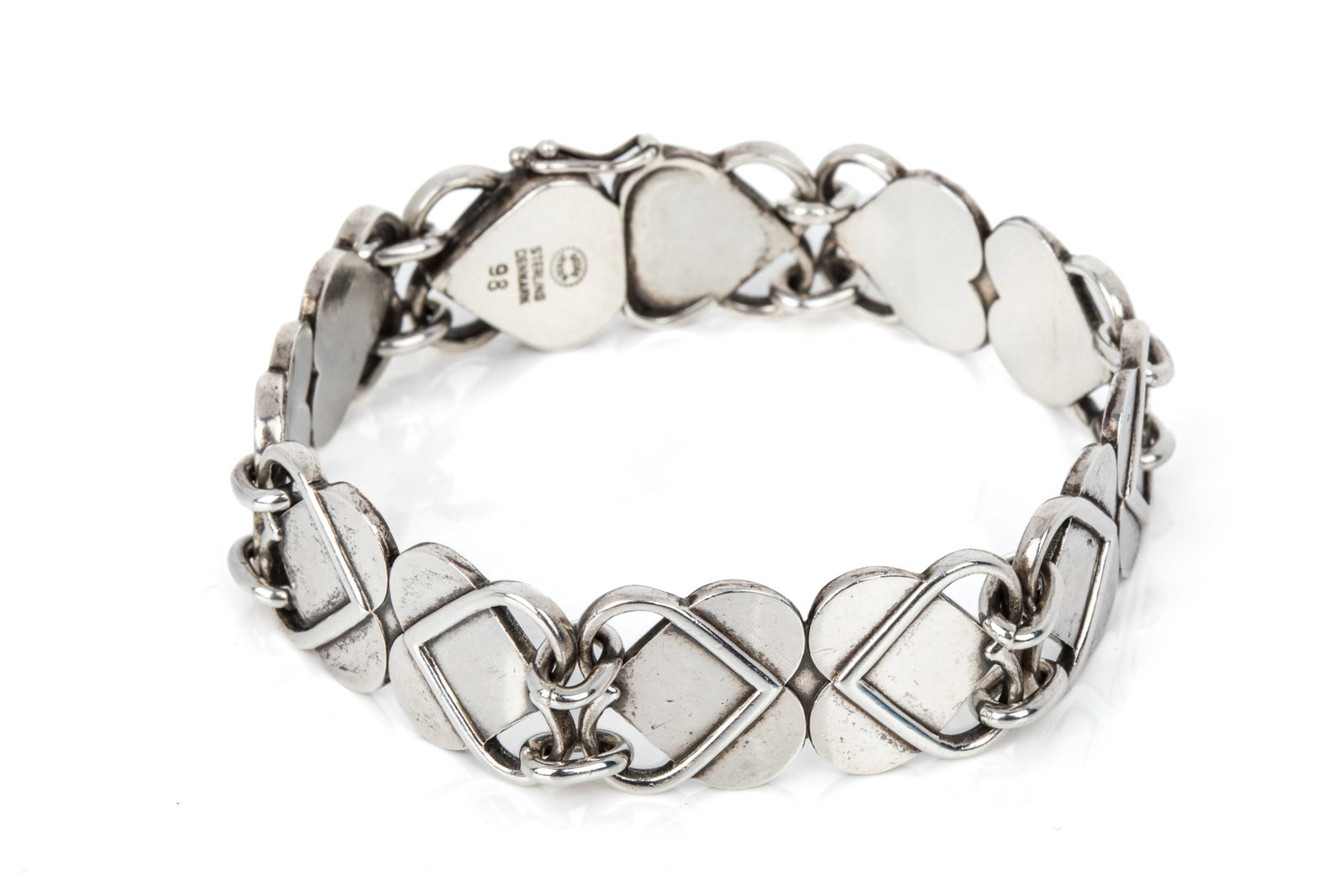 GEORG JENSEN & ARNO MALINOWSKI HEARTS BRACELET 98: Vintage Georg Jensen sterling silver Hearts bracelet model 98, design attributed to Arno Malinowski. Measuring 7.25 inches wearable length by 14.7mm wide, equipped with box catch. Post-1945 hallmarks.