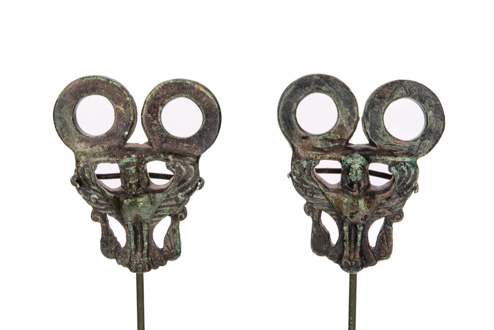 TWO ANCIENT BRONZE AMULETS: Probably Etruscan with winged figural motifs. H. 3 1/2" x W. 2 3/4" On an acrylic base measured H. 1/2" x L. 5 1/2"