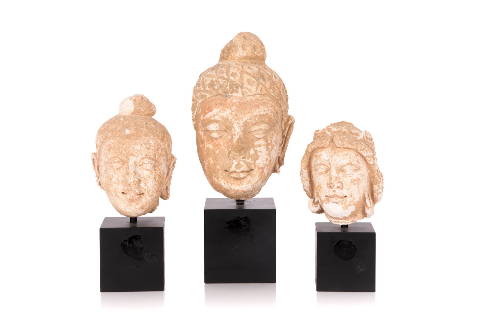 THREE CARVED STONE BUDDHA HEAD SCULPTURES: H 11 1/4in (28.5cm) x L 3 1/2in (9cm)