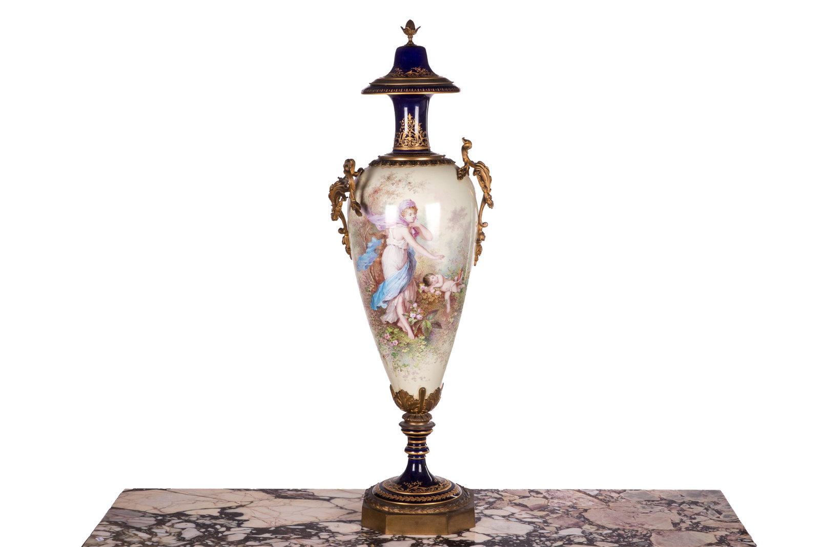 FRENCH SEVRES-STYLE HAND PAINTED PORCELAIN URN: An impressive French Sevres-style cobalt blue porcelain urn, finely chased gilt-bronze mounts on the twin handles, rim, and base. The baluster-form body is beautifully decorated with a woman and Cupid