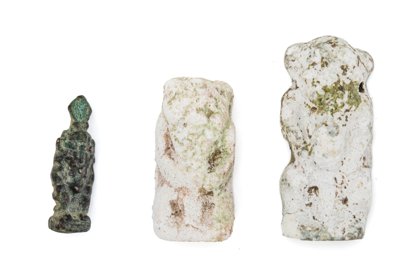 THREE ANCIENT EGYPTIAN SCULPTURES OF BES: One bronze pendant and two stones sculptures of Bes, the protector of households, mothers, children, and pregnant people. Depicted with lionesque features on one and a feathered crown on the other. Br