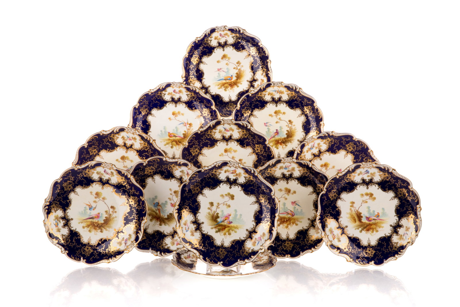 12 pc. SET OF COALPORT PORCELAIN CABINET PLATES: Early 20th century. Comprising 12 cobalt blue and gilded porcelain plates with scalloped rims, each featuring hand-painted reserves signed F. Howard. Underside with Coalport manufacturer marks, patter