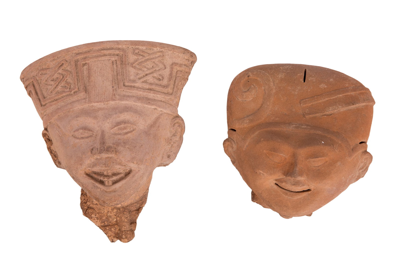PRE-COLUMBIAN FIGURAL FRAGMENTS: Possibly sonrientes, dating from the Classic period of Mesoamerican history. One is ceramic, the other is stone. Both depict young, smiling faces with adornments on ears, neck, and head. Age not
