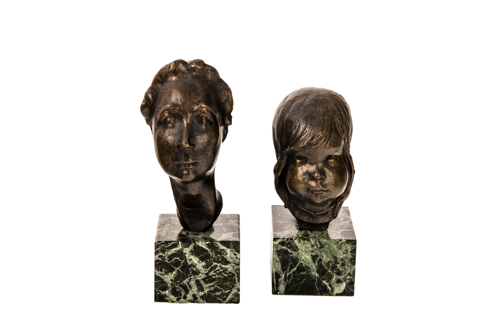TWO PORTRAIT BUSTS MOUNTED ON MARBLE: Includes 2 small sculptural portrait busts featuring the head and neck of a young child and an older figure, designed in a soft, impressionist style that emphasizes tender, hand-sculpted contours. Eac