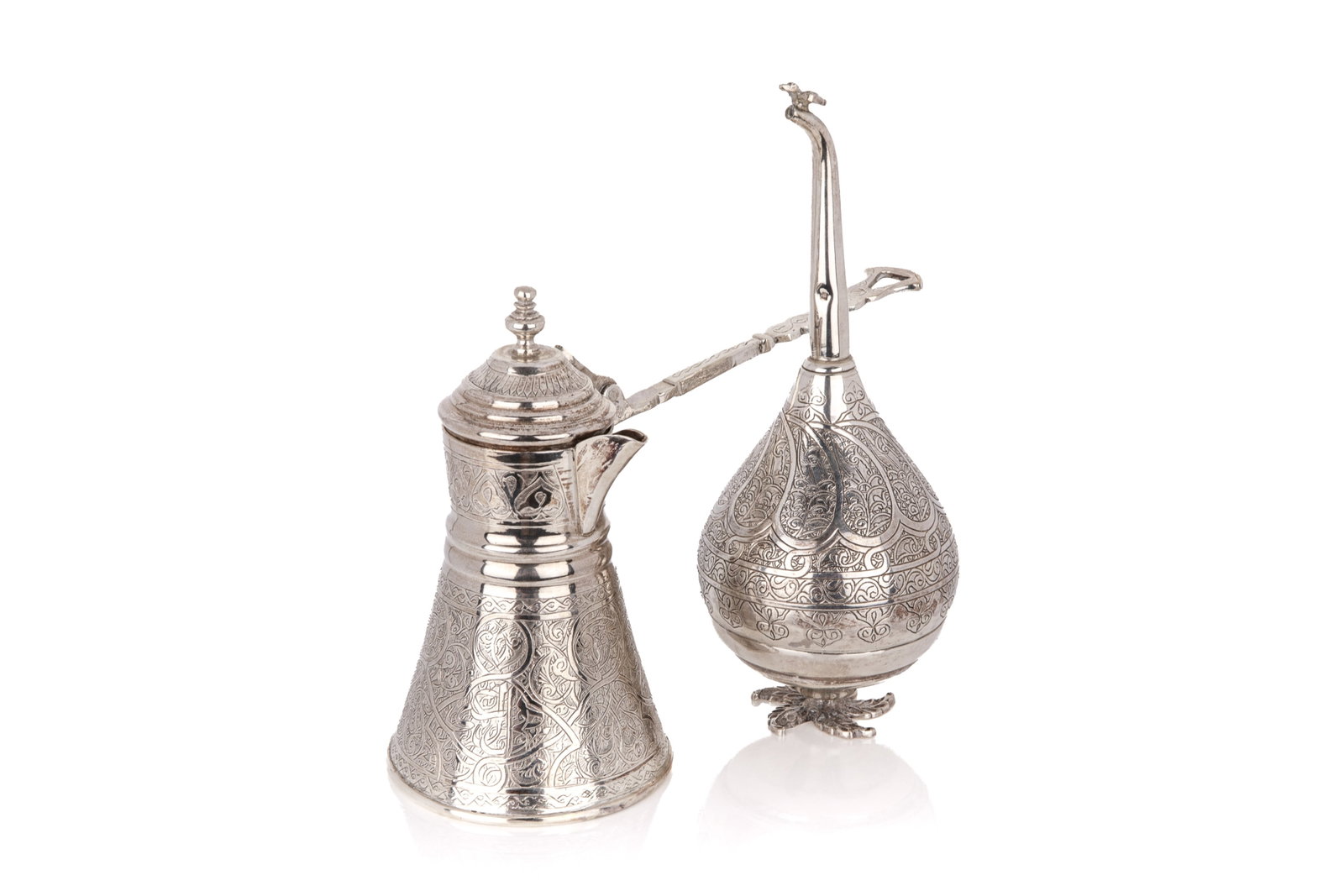 TWO EGYPTIAN SILVER TABLE ARTICLES, 335g: 2 silver middle-eastern table articles. Includes 1 rosewater bottle raised on a scrolling leaf foot; and 1 Turkish coffee pot. Both stamped with Cairo hallmarks. Overall weight 335grams Coffee pot L.