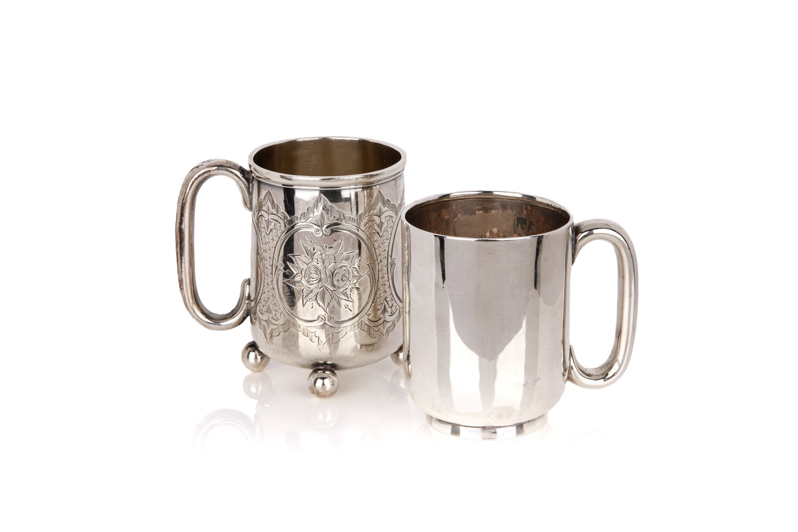 TWO VICTORIAN AND EDWARDIAN SILVER MUGS, 177g: Comprising 1 plain form mug hallmarked George Nathan & Ridley Hayes, Chester, 1907; and 1 mug chased with floral cartouches, hallmarked George Unite & Sons, Birmingham, 1876. Overall weight 177grams