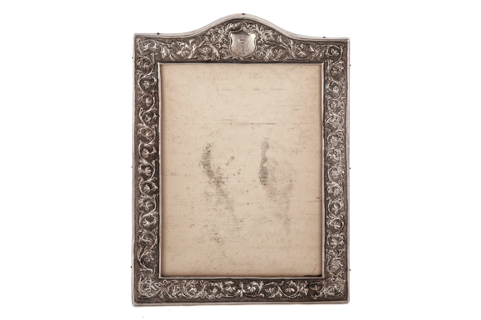 ANTIQUE SILVER PICTURE FRAME: Late 19th/20th Century. A repousse silver picture frame with chased floral and foliate scrolls. Weight 253grams (silver on wooden frame; excluding glass and backing) H. 10 5/8in x W. 7 1/2in (27cm x