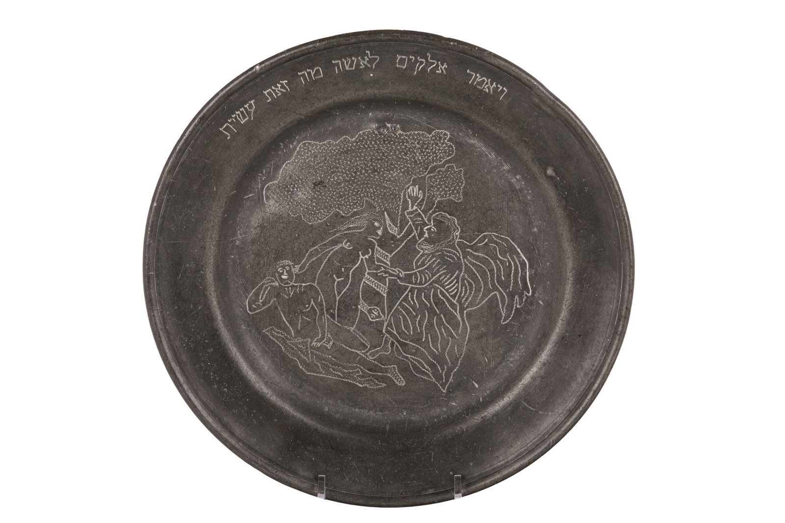 UNUSUAL JUDAICA PEWTER DISH: Engraved with Adam and Eve in the Garden of Eden with God, the tree and serpant, Hebrew text. Probably European, 19th C. Dia 23.3cm (9 1/8in)