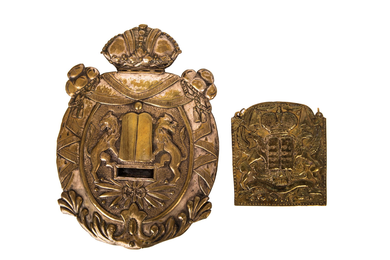 TWO ANTIQUE BRASS TORAH SHIELDS TAS: The larger pressed silverplated on brass with lions and crown finial, back plate with Continental silver mark. Smaller brass with arc with Hebrew text.H of larger 32.5cm (12 3/4in)