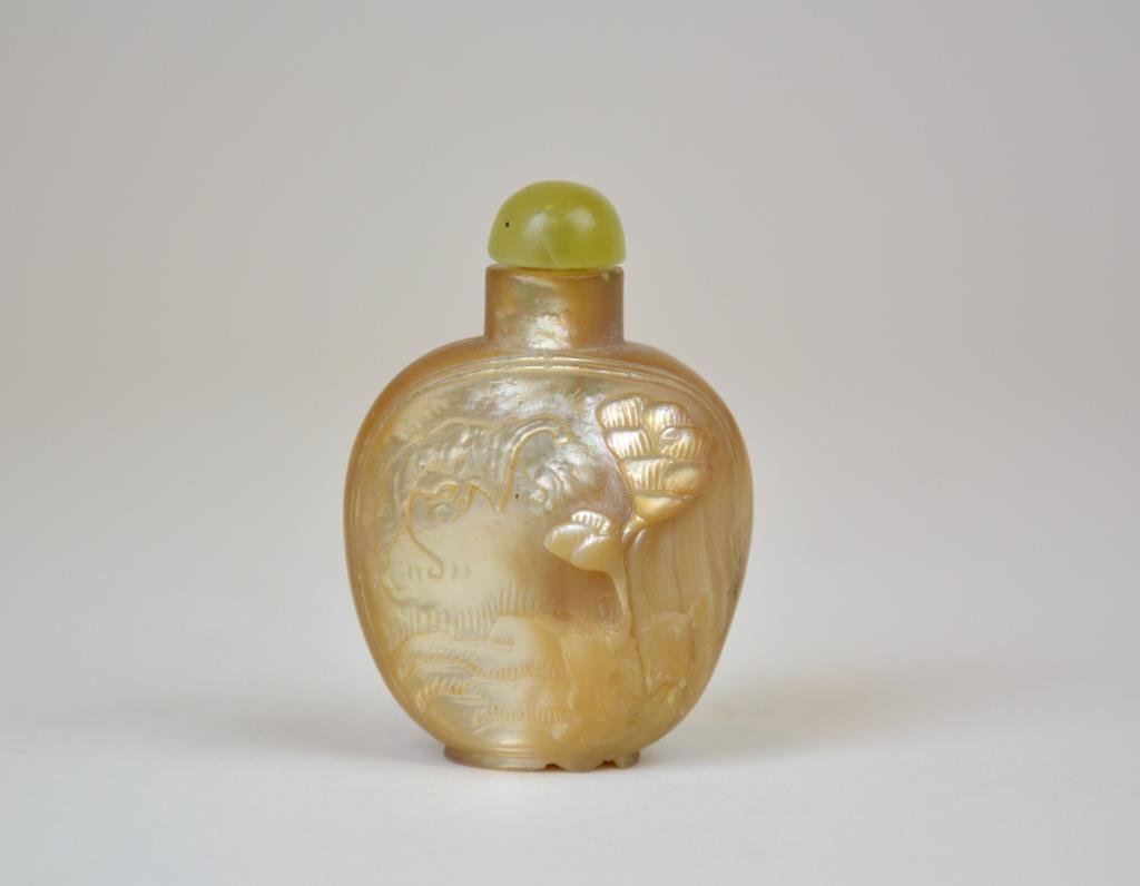 Chinese Carved Abalone Snuff Bottle: Carved on one side with bat and pine tree and the other side with two qilins, with nephrite stopper. H. 6.5cm (2 5/8 in.)