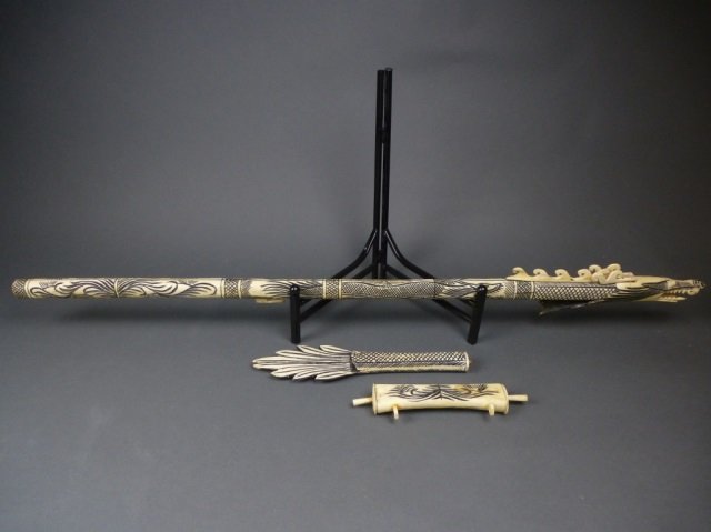 Borneo carved dragon bone blow dart gun with case: gun with dragon's head at mouth. Case with strap for carrying. Does not come with darts. For decorative purposes only. Length: 47 in.