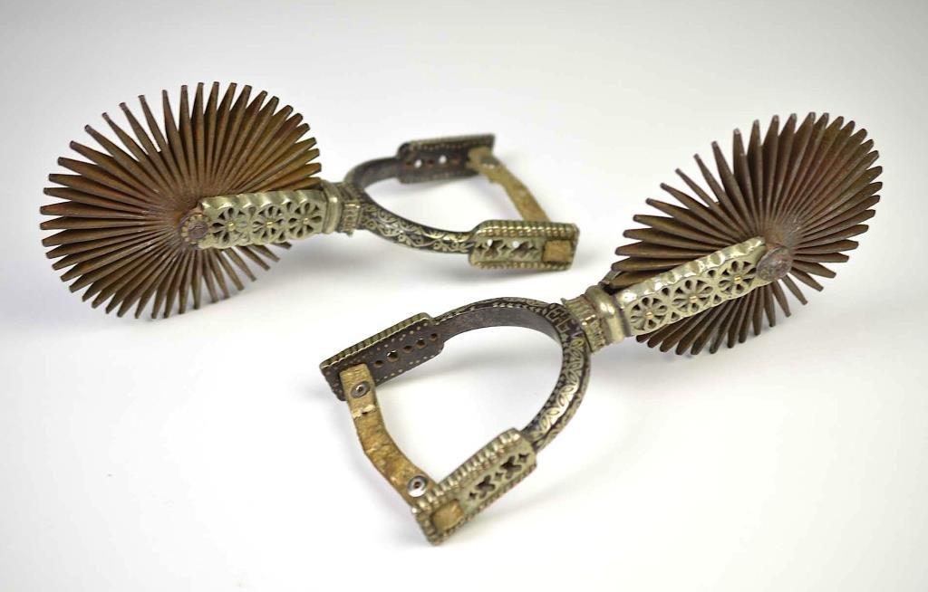 PAIR OF SPANISH COLONIAL IRON SPURS: With fine silver overlay and pierce-work, owners initials EL, 5 inch wheels (rowels), 19th century. L 24 cm (9 1/2 in)