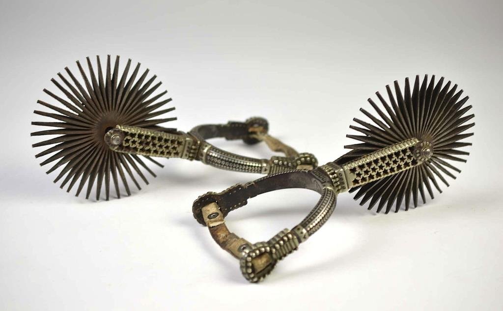 PAIR OF SPANISH COLONIAL IRON SPURS: With geometric silver inlay, 5 inch wheels (rowels), 19th century. L 24 cm (9 1/2 in.)