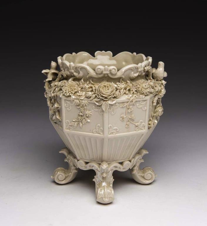 BELLEEK FOOTED PANEL FLOWER POT: With applied floral swags and birds, rubbed first mark to base. Model number D50 in the 1904 catalogue. H 28.5 cm (11 1/4 in.)