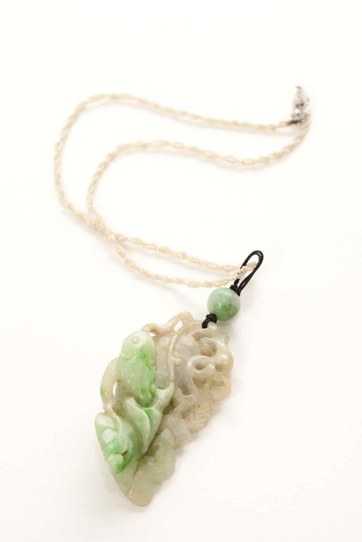 CHINESE CARVED JADEITE NECKLACE: Apple green jadeite carved as a fish figural group, with a 14K white gold clasp and natural seed pearl chain. L. of jadeite 6cm (2 3/8 in.)