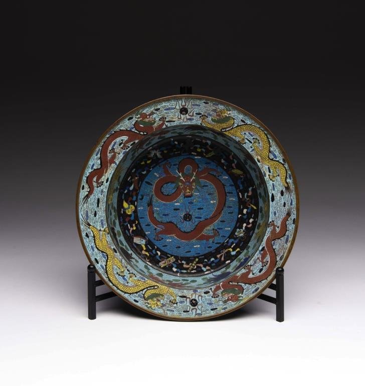 CHINESE 19th CEN CLOISONNE BASIN: Interior centre has a red five-claw dragon and a band of fish, top rim has four more dragons. Exterior decorated with bats and shou symbols against floral ground. 19th century. Dia. 37.5cm (14 3/4 in.