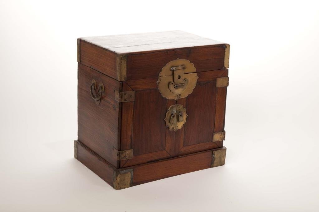 CHINESE BRASS AND HUANGHUALI WOOD SEAL BOX: Cover opens to a mobile tray, multi-level shelving behind doors, with two loop handle on both sides. Huanghuali wood facade. H. 45cm (17 3/4 in.), W. 23.2cm (9 1/8 in.), D. 15.2cm (6 in.). 17th/18th c