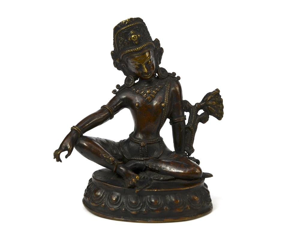 BRONZE SEATED FIGURE OF INDRA, NEPAL: In lalitasan (royal ease) pose on lotus base, adorned with various jewellery, a lotus blossoming over her shoulder. H. 16.5cm (6.5 in.) Good patina, no bruise Weight: 943g.