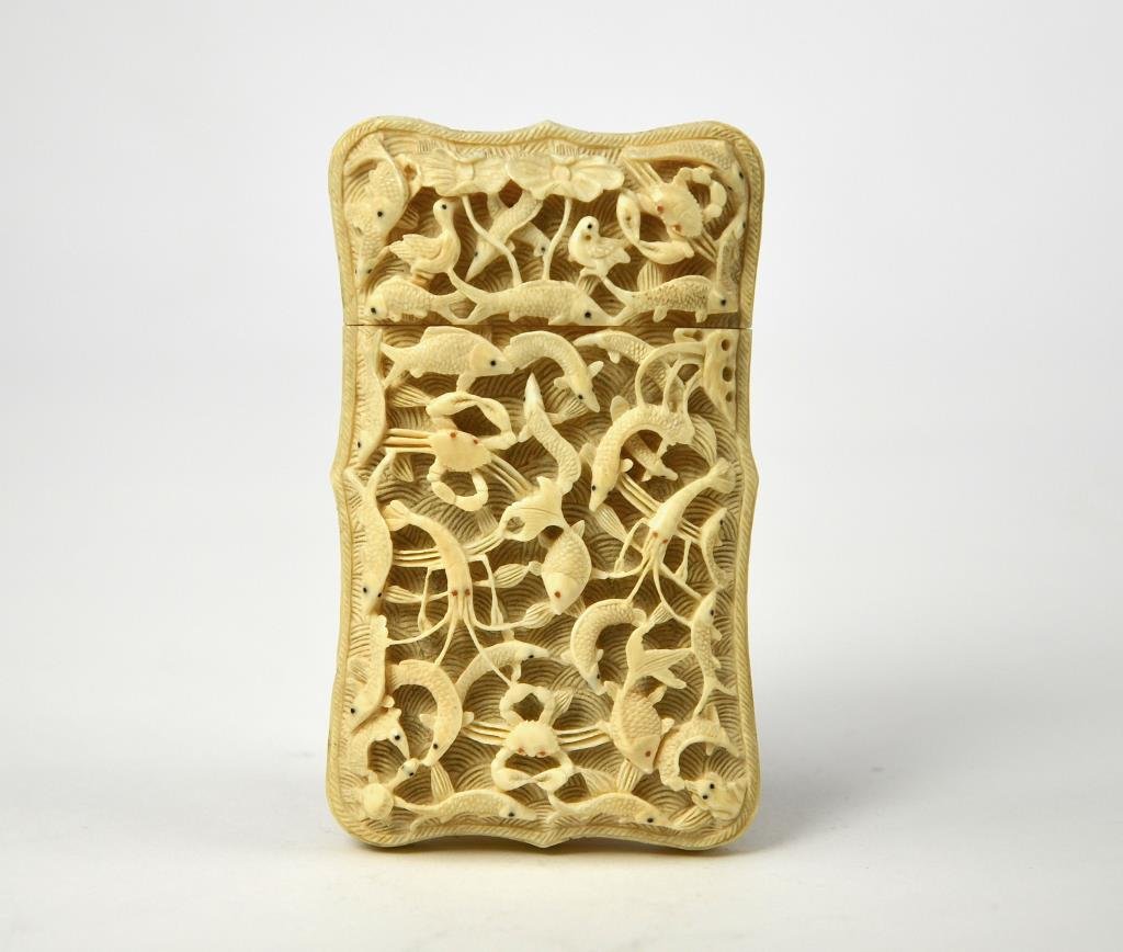 CHINESE EXPORT CARVED IVORY CARD CASE: Finely carved and pierced on one side with sea creatures, the back with figures in a pavilion landscape and previous owner's name engraved in centre. mid 19th century. L. 9.7cm (3 7/8 in.) From the co
