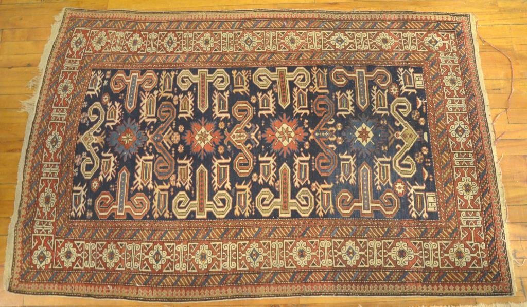 ANTIQUE CAUCASIAN KUBA RUG: Red and navy ground with a kufic border, late 19th C . 65 in. x 41 in.