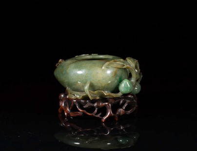 CARVED JADEITE PEACH FORM WASHER: Decorated with carved bat and peaches on body. On finely carved fitted wood stand. W. 11.5cm (4.5 in.)