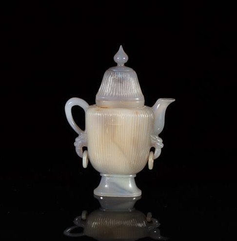 CARVED AGATE MUGHAL STYLE COVERED WINE POT: Grey-light lavender colouration with ribbed body accented by two lose rings. H. 17cm (6 3/4 in.)