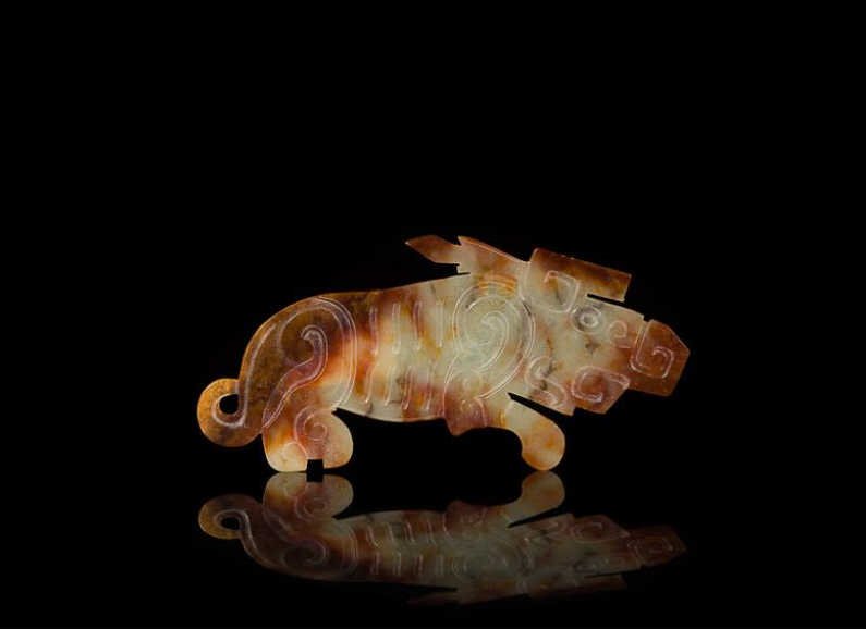 FINE RUSSET & WHITE JADE DEER: Very thin body and carved to accentuate the eyes, horns and ribs of the figure, Shang Dynasty. W 9 cm. (3 1/2 in.) From the Irving Langleb collection, a prominent Jewish gentleman who resided in Japan