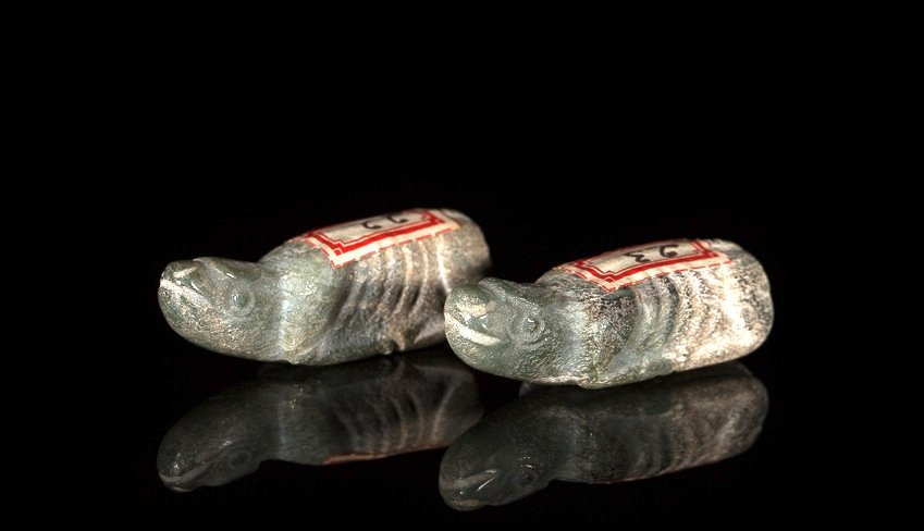 PAIR OF JADE RITUAL BURIAL BUFFALO: Calcified green jade with finely carved horns, tail and body, possibly Shang. L 4.8 cm. (1 7/8 in.) From the Irving Langleb collection, a prominent Jewish gentleman who resided in Japan post-WWII and