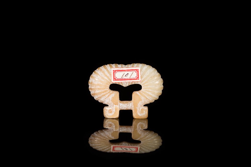 YELLOW JADE BELT BUCKLE: Ruyi form with ribbed body and fretwork to buckle, calcified surface, Ming Dynasty. W 5.2 cm. (2 1/8 in.) From the Irving Langleb collection, a prominent Jewish gentleman who resided in Japan post-WWI