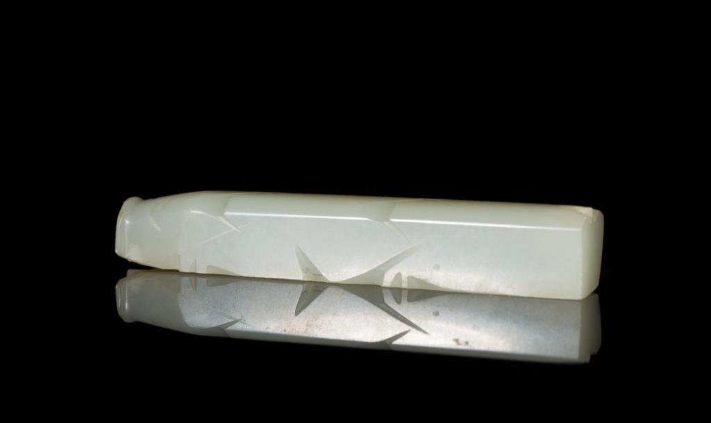 WHITE-LIGHT CELADON JADE 8-CUT BURIAL PIG: Cut on two sides with a flat base and small hole in the tail. Han Dynasty. L 9.2 cm. (3 5/8 in.). From the Irving Langleb collection, a prominent Jewish gentleman who resided in Japan post-WWII and wa