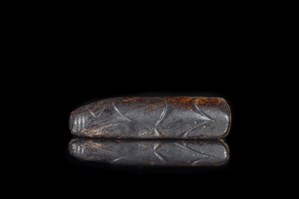 BROWN JADE 8-CUT BURIAL PIG: Cut on three of the four sides of the pig in an elongated form, Han dynasty. L 10.8 cm. (4 1/4 in.) From the Irving Langleb collection, a prominent Jewish gentleman who resided in Japan post-WWII and 