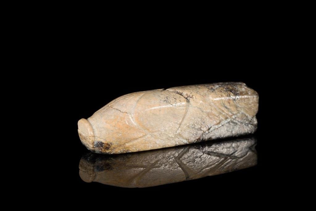MOTTLED JADE 8-CUT BURIAL PIG: Opaque black to cream ground, well cut on three sides with a flat base, Han Dynasty. L 8.3 cm. (3 1/4 in.) From the Irving Langleb collection, a prominent Jewish gentleman who resided in Japan post-WW
