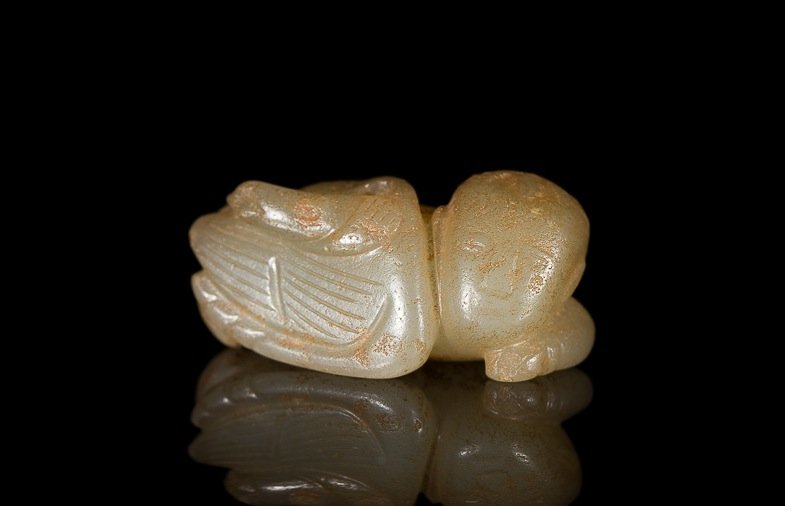 AN EARLY CARVED BEAD FIGURE OF A BOY & SWAN: Light celadon green-white jade of a reclining boy and swan with fine detail, probably Han dynasty. W 3.5 cm. (1 3/8 in.) From the Irving Langleb collection, a prominent Jewish gentleman who resided in