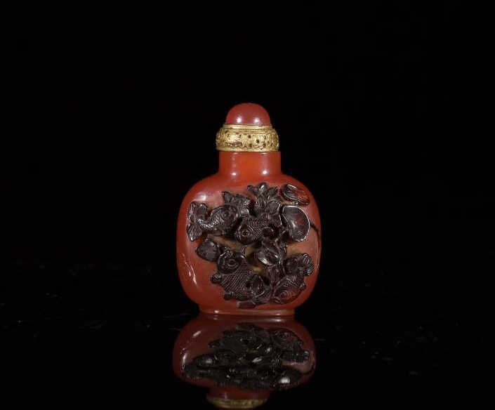 CARVED GLASS SNUFF BOTTLE: Carnelian burnt orange body with brown overlay fish and lotus, incised calligraphy poem, matching stopper. H 8 cm. (3 1/4 in.)