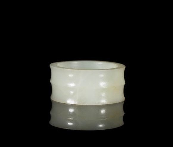 WHITE-LIGHT CELADON JADE HAIR TOGGLE: Of two concave bands, simple interior with signs of hand carving. Possibly from the Han Dynasty. Dia 5.5 cm. (2 1/8 in.) Note: Similar example found in: Jades from China, by Forsyth and McElney, image