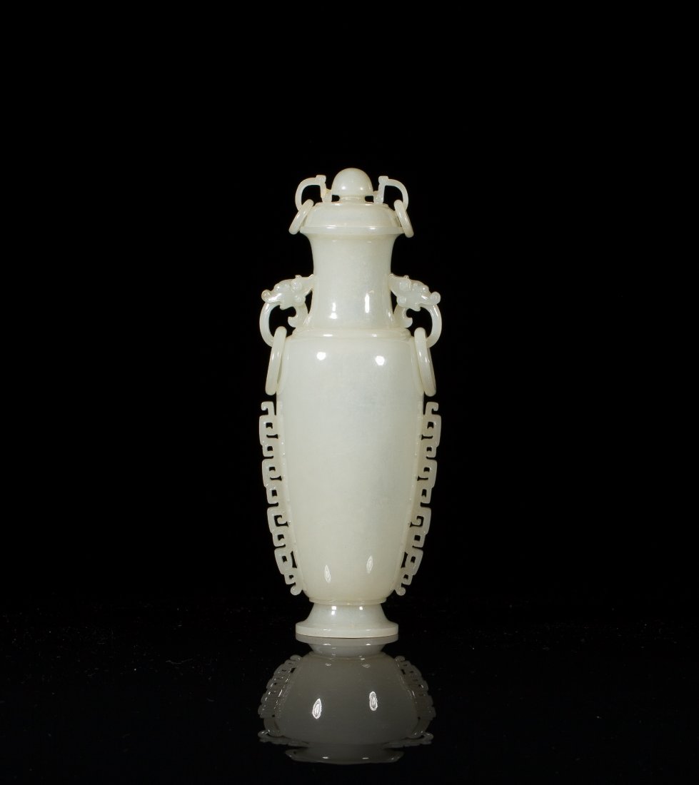 FINELY CARVED JADE MUGHAL STYLE COVERED VASE: Willow vase with carved scrolling ruyi-head panels on body. Double dragon-head handles with loose rings. On carved fitted wood stand. H. 17.8cm (8 in.) From the Irving Langleb collection, a prominent 