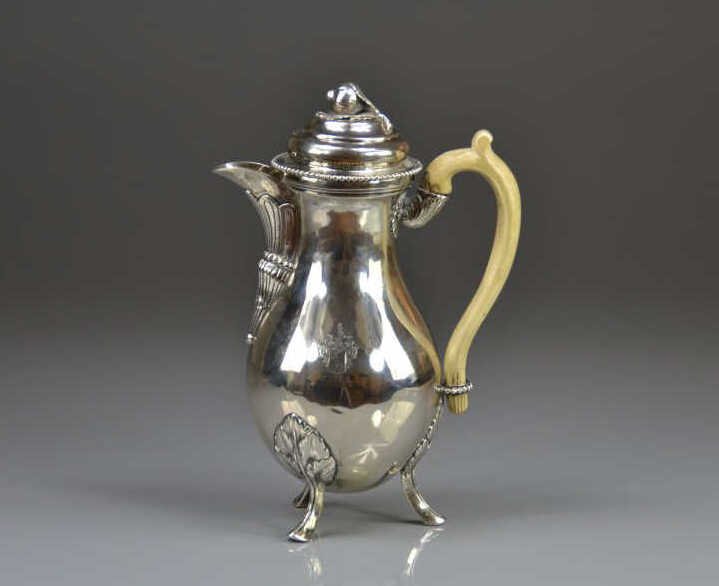 AUSTRO-HUNGARIAN SILVER COFFEE POT: Tirnau, circa 1788, maker MS. A baluster form pot on three cast feet with an ivory handle. The beaded lid mounted with a Hazel nut finial. Decorated with an engraved coat of arms. 750 gm. Height 25 cm