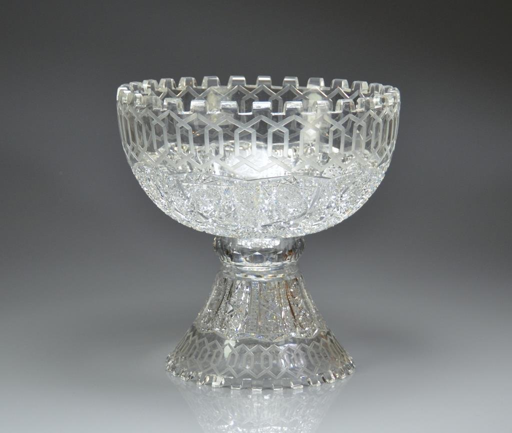 AMERICAN GLASS ALHAMBRA PUNCH BOWL ON STAND: Large brilliant cut bowl with hob star panels and hexagonal bands atop an alike flared pedestal base. Probably by Meridan Cut Glass Company. Retailed by Roden. Diameter 31.5 cm. Height 31 cm. Nicks to