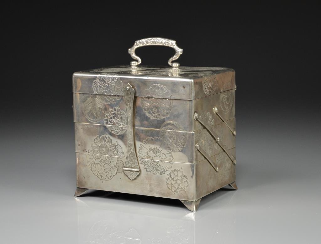 JAPANESE SILVER JEWELLERY BOX: Three stacked box with engraved floral sprays and red velvet lined interior. Hinged back and foliate handle,. H 12.7 cm. (5 in.)