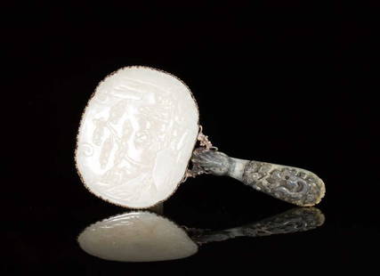 WHITE CHINESE JADE MOUNTED SILVER HAND MIRROR: Large white jade oval ruyi plaque carved with pine tree and shoulao carrying a peach set in a silver mounting joined to a two-toned gray and celadon jade belt hook with dragon-head handle and the buck