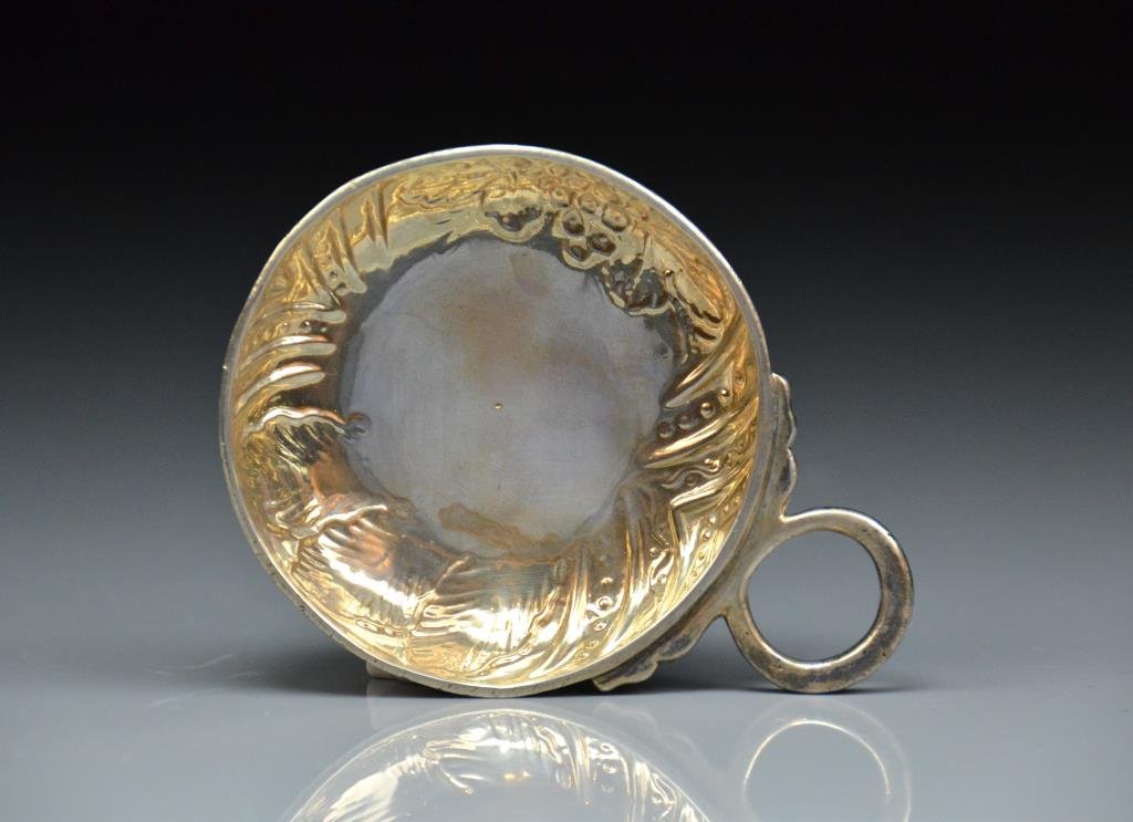 FRENCH 18th C. SILVER WINE TASTER: Angers, France, 1742. Early silver wine taster of typical style, with repousse grape and vine motif, owner's name engraved to rim. 74g. 7.6 cm / 3 in.