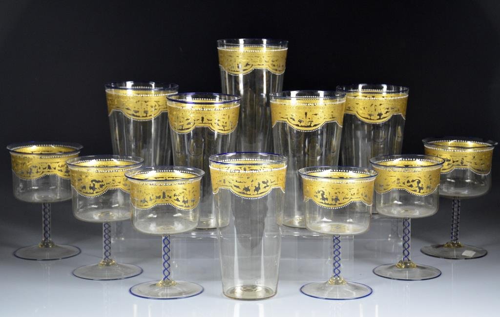 TWELVE FINE ITALIAN MURANO GLASSES: Attributed to Salviati, gold stenciled design lined in white enamel beading. Blue air twist stems and blue rims, early 20th C. Includes six high balls and six large wine stems. H of high balls 15.2 cm