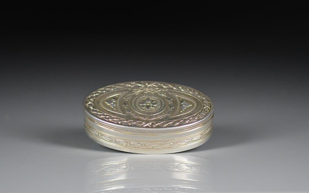 FRENCH OVAL SHAPED SILVER SNUFF BOX: French, 1883-1911. Maker: Alphonse Debain. Decorated with floral medallion and concentric wreathes. L: 7.5cm (3 in.) 64g.