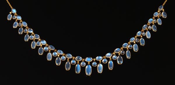 A moonstone fringe necklace, the graduated oval mo: A moonstone fringe necklace, the graduated oval moonstone cabochon drops with round drops between, on a belcher link back chain, 39