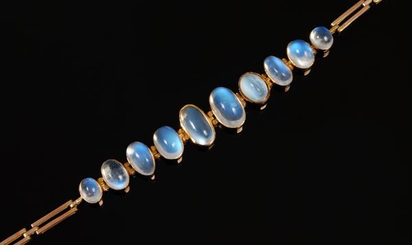 A moonstone bracelet, set with 10 graduated moonst: A moonstone bracelet, set with 10 graduated moonstone cabochons to rectangular end links and a concealed box snap clasp, 17cm long<