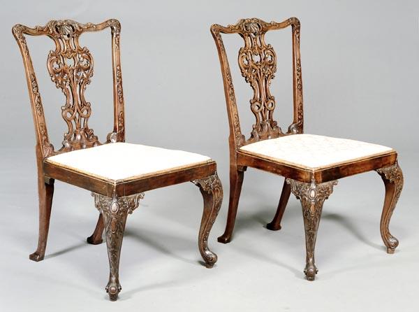 A pair of George III carved mahogany side chairs,: A pair of George III carved mahogany side chairs, in the manner of Thomas Chippendale, circa 1770, the ornately carved rectangular back with shaped toprail centred by a shell above a pierced